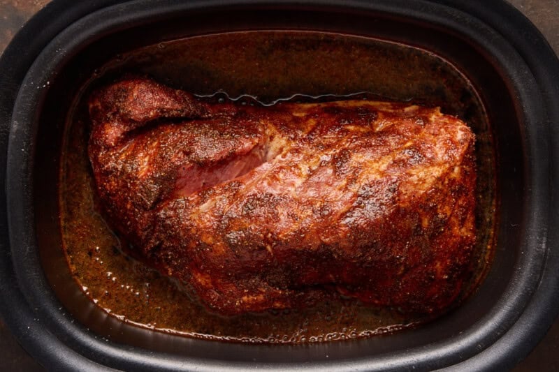 Pork shoulder ready to cook in a slow cooker.