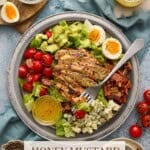 Honey Msutard Marinated Chicken grilled and sliced on top of a cobb salad.