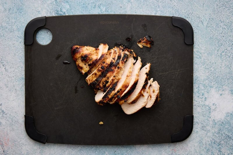 Grilled Chicken breast sliced on cutting board.