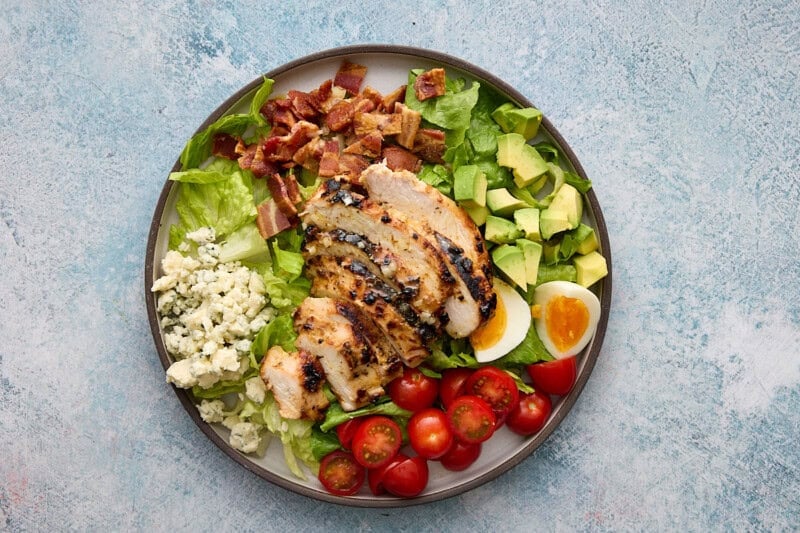 sliced chicken breast on top of the assembled cobb salad.