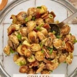 A glass bowl filled with grilled potato salad with bacon.