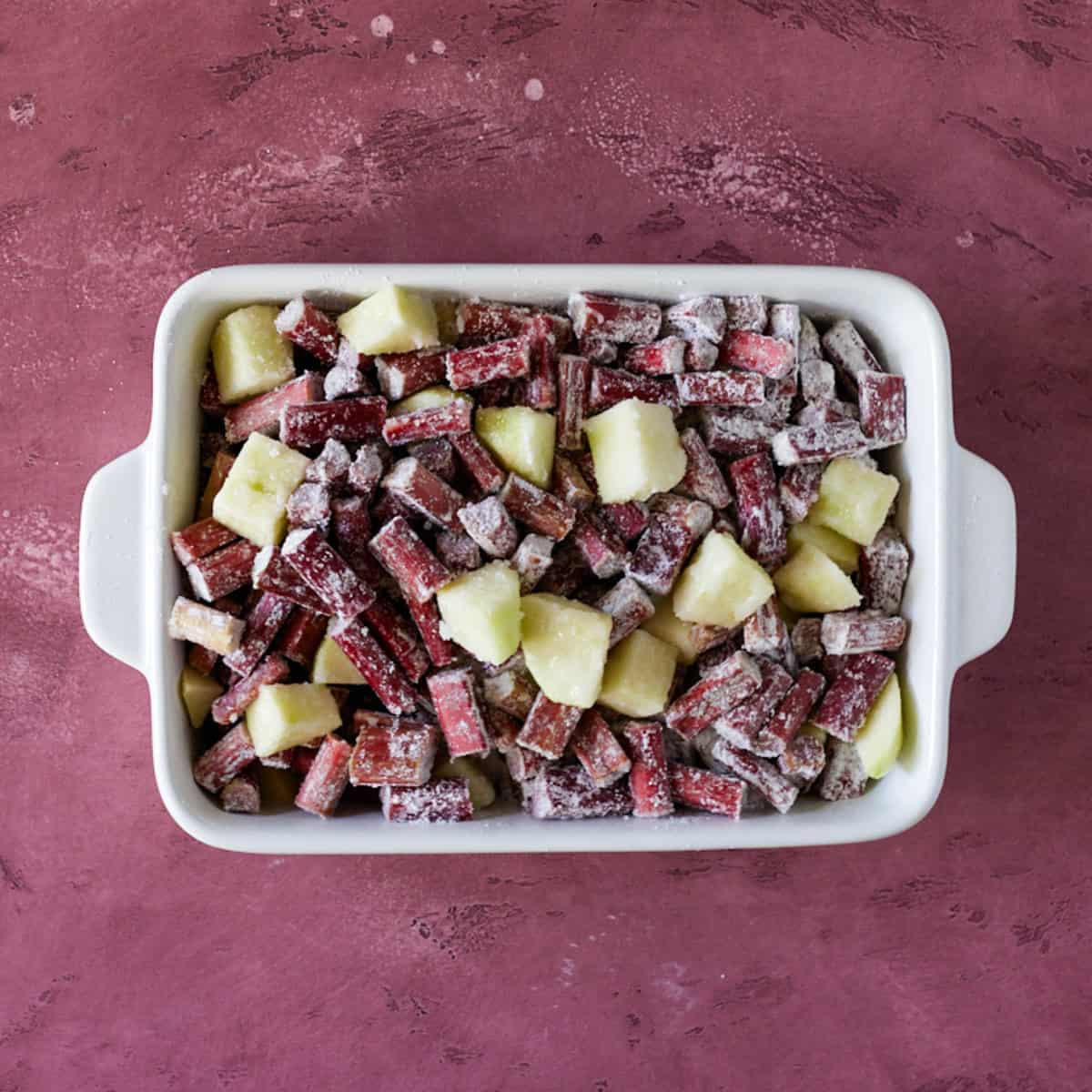 Apples and rhubarb in baking dish.