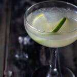 A twisted lime slice in a coupe glass filled with classic daiquiri cocktail.