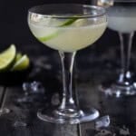 A classic daiquiri cocktail in a coupe glass garnished with a lime slice.