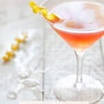 Cosmo Cocktail with lemon twist on white background.