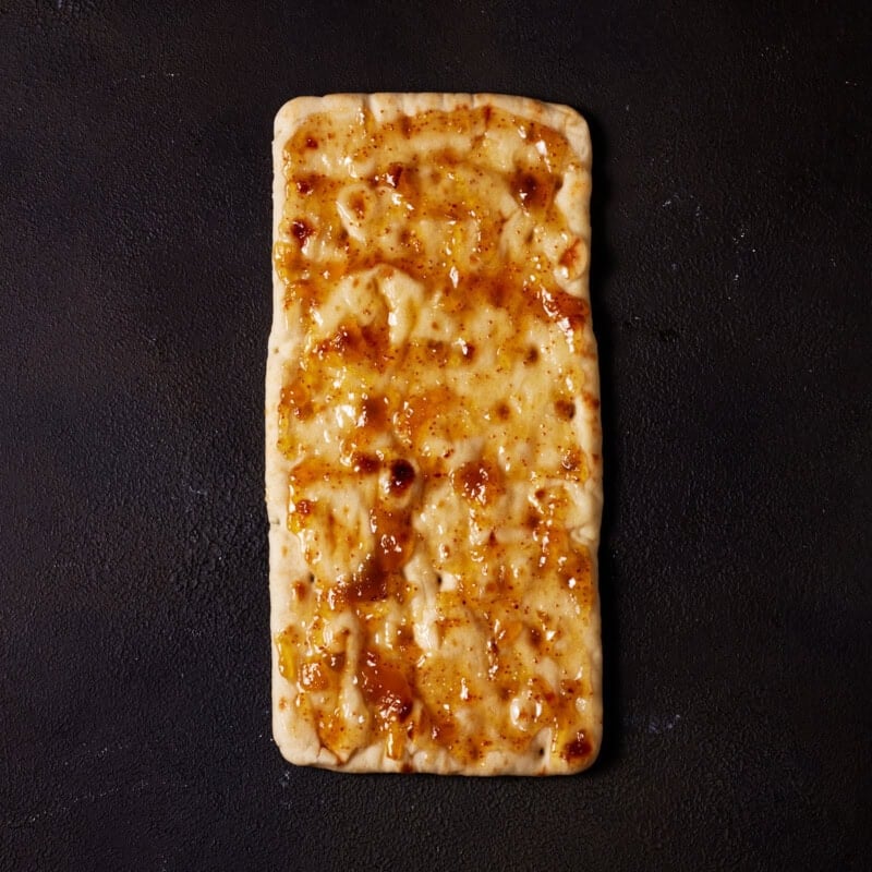 A flatbread spread with a thin layer of fig jam.