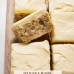 One Banana bar with Cream Cheese Frosting propped up on top of other cut bars.