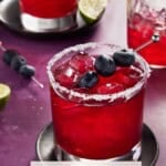 Two Blueberry Margaritas with a partially filled shaker.