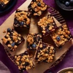 Blueberry Oat Crumble Bars cut into squares on a copper wire cooling rack.
