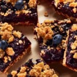 Blueberry crumble bars on brown parchment paper.