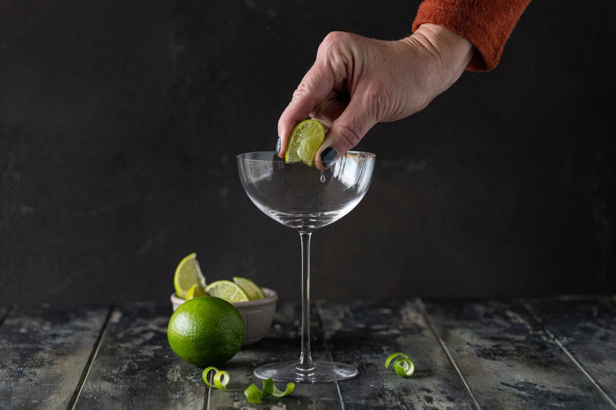 Lime being squeezed into glass.