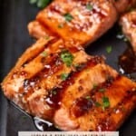 Grilled sockeye salmon fillets brushed with a maple ginger glaze on a dark sheet pan.