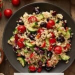Mediterranean Quinoa Salad on q gray plates with fresh tomatoes and lemon.