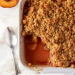 Top down shot of peach crumble with a corner of the crumble removed.