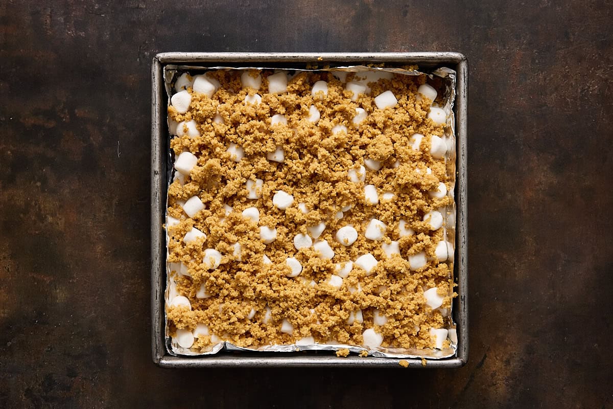Unbaked s'mores bars in a square metal pan.