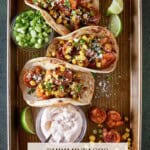 Shrimp Tacos with lime wedges and chipotle crema.