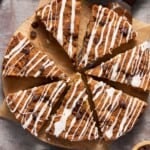 Sour Cream Chocolate Chip Coffee Cake sliced into wedges on a board with a spatula and a cup of coffee.