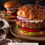 Turkey burgers on sesame buns with toothpicks in top and goat cheese.