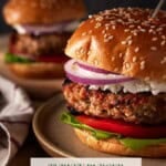Turkey burgers on brown plate with toothpick in top of bun.