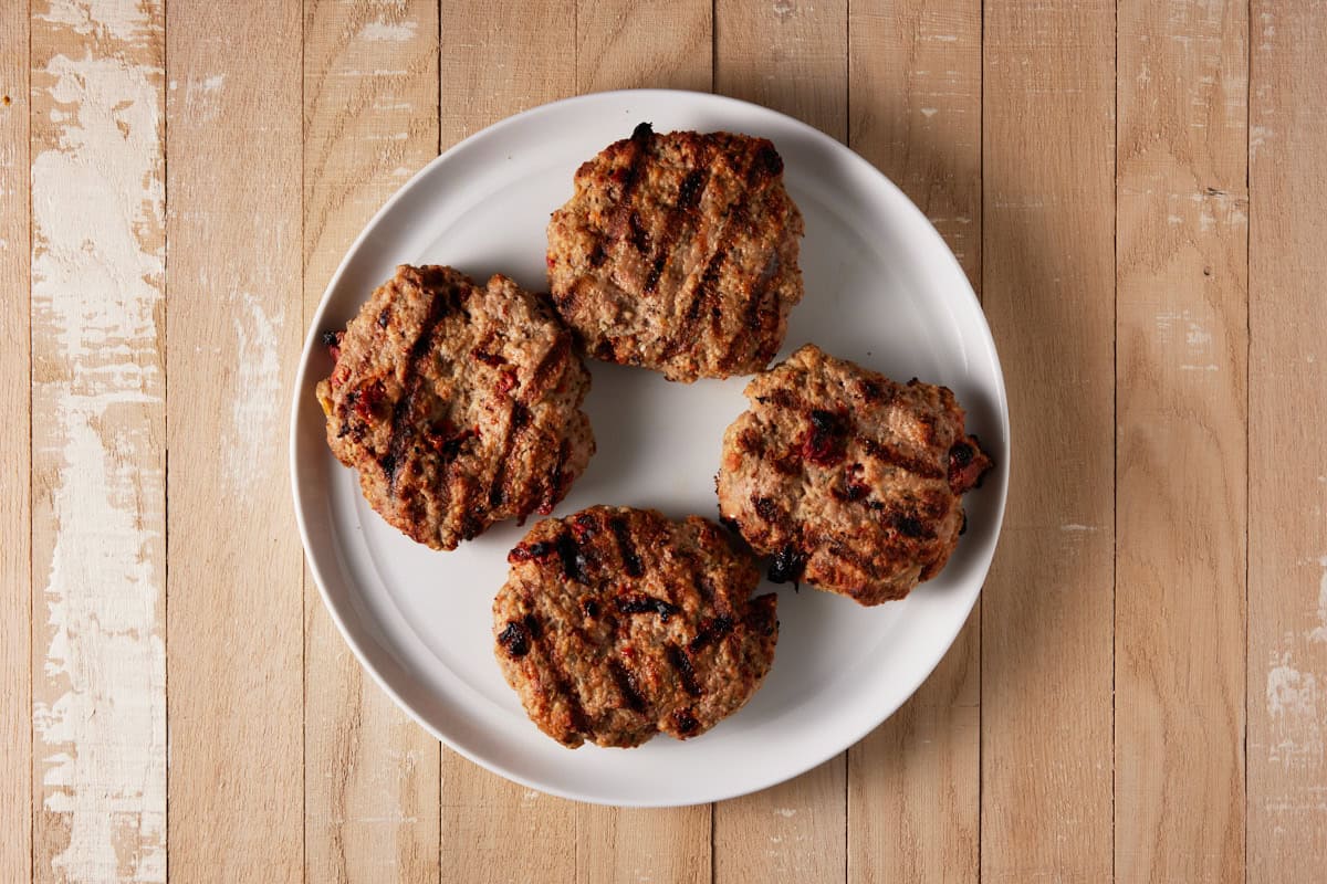 Grilled turkey brugers on plate.