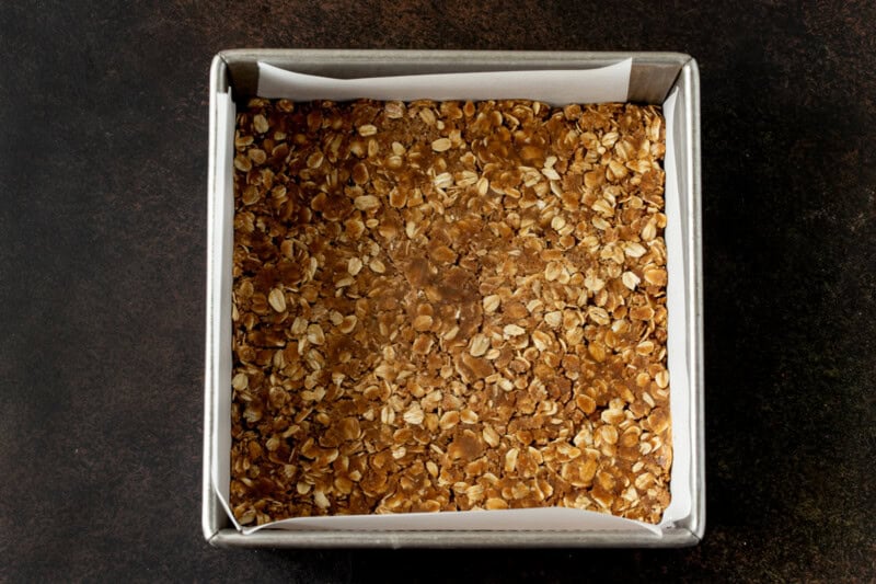 A classic oat crumble topping pressed into the bottom of an 8x8 metal pan.
