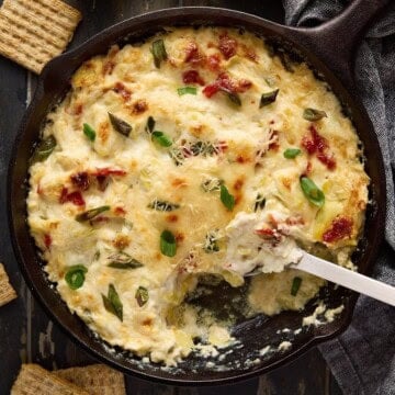 Asiago artichoke dip in a cast iron pan.