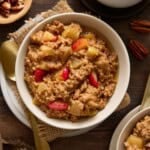 Two bowls of baked steel cut oatmeal with apples and cinnamon and a cup of coffee.