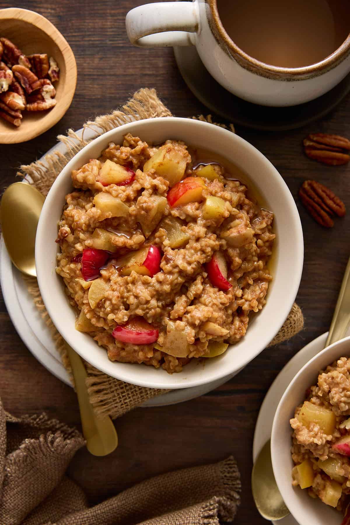 Steel cut oatmeal in bowls with maple syrup and pecans.