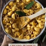 A white pot of creamy pumpkin pasta with a sausage and sage sauce.