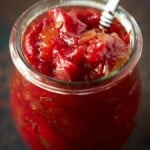 Glass jar filled with homemade chunky homemade tomato jam.