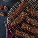 A cooling rack with slices of candied bacon on top.
