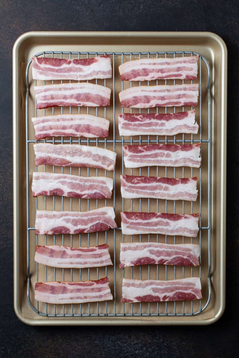 Raw Bacon cut in half on rack to bake.